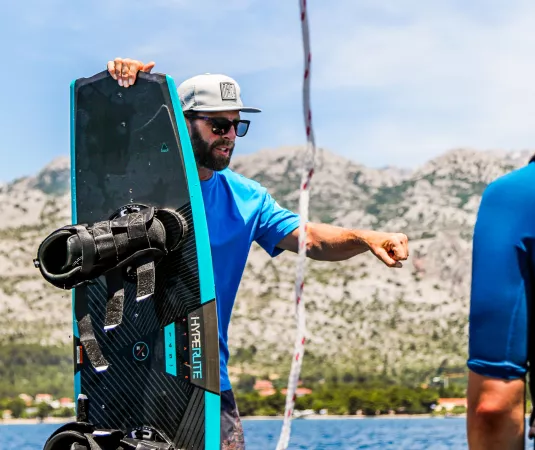 Matt Crowhurst holds a wakeboard while instructing riders
