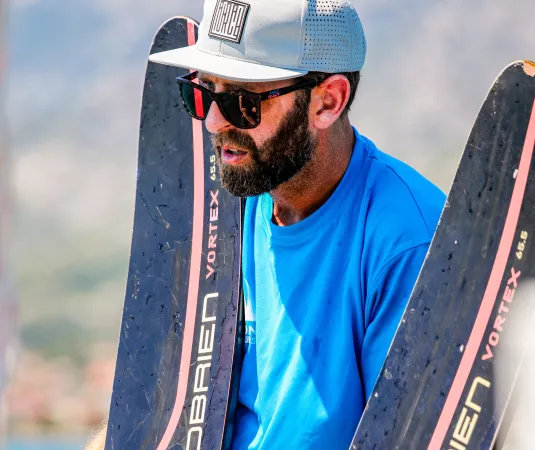 Matt Crowhurst holds a pair of waterskis while delivering a lesson