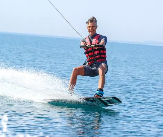 A man wakeboarding on a calm sea