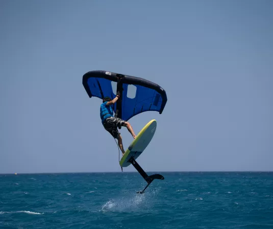   a person engaging in wing foiling on the ocean