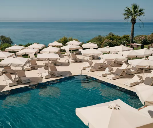 a luxurious outdoor pool area overlooking a tranquil body of water.