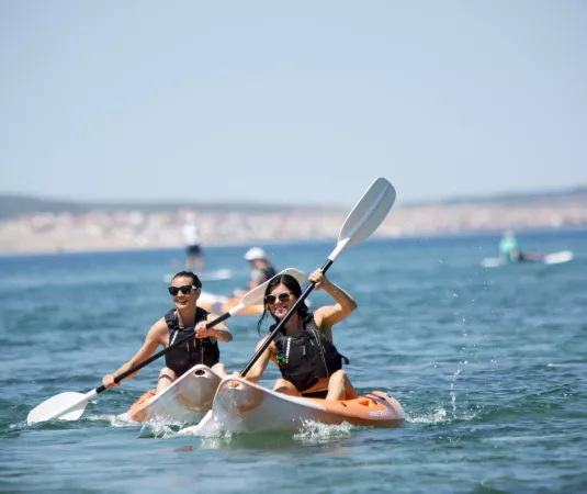 2 women kayaking at Alana beach club