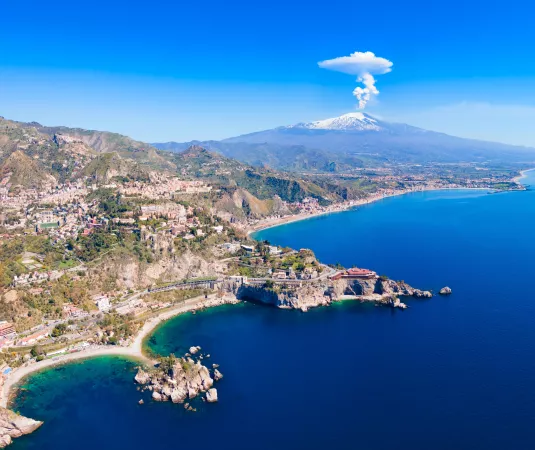 A panorama of the Sicily coast with Mount Etna in the background