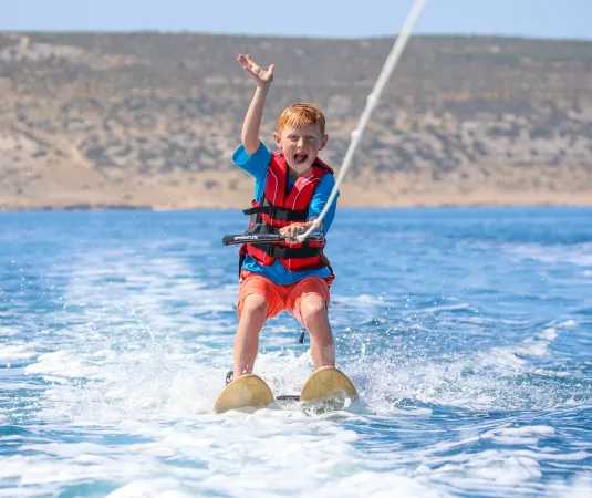 A child waterskiing at Alana beach club
