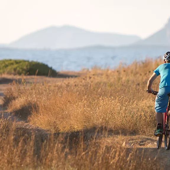 Man mountain biking by the sea in Sardinia