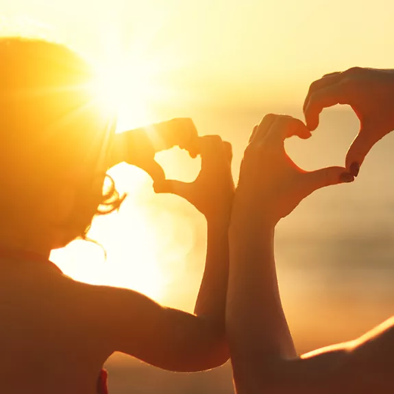 Woman and child on beach at sunset