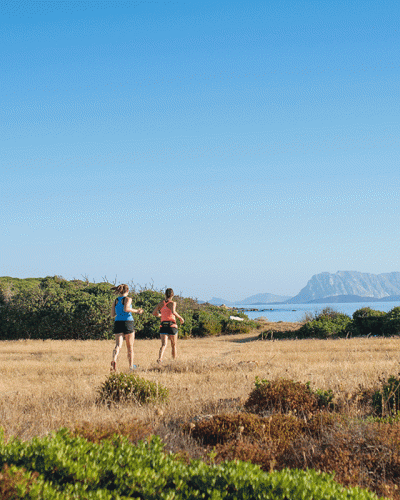 Two women running by the sea in Sardinia