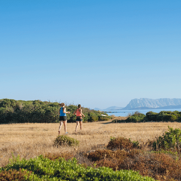 Two women running by the sea in Sardinia