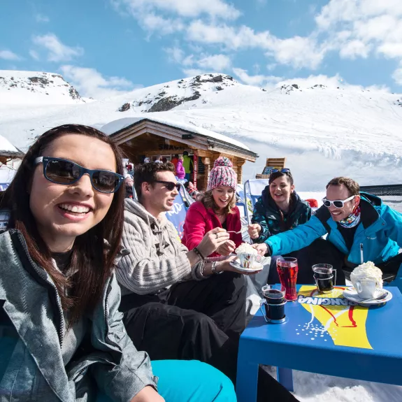 group of friends enjoying a drink in a cafe on a ski holiday