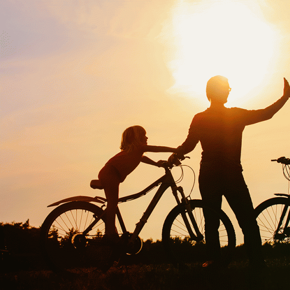 Family cycling at sunset