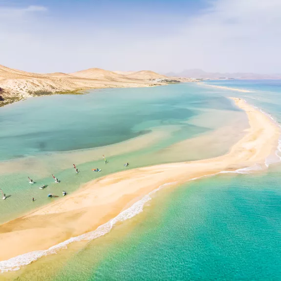 Aerial view of people windsurfing in shallow water
