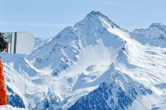 man standing holding a snowboard