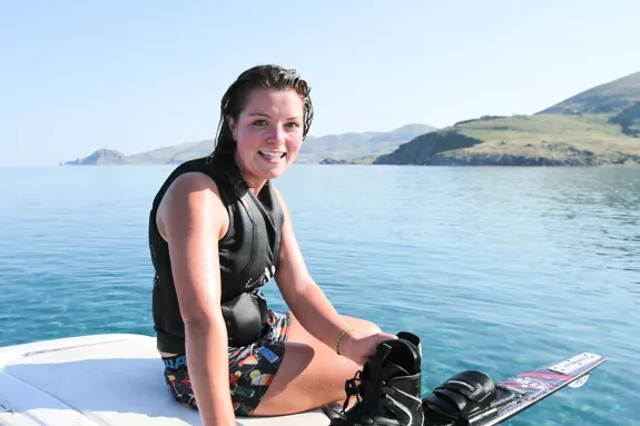 Girl on back of boat after water skiing