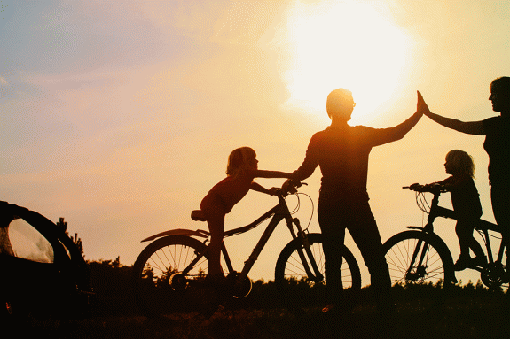 Family cycling at sunset