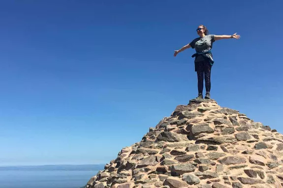 Girl standing in top of pile of rocks