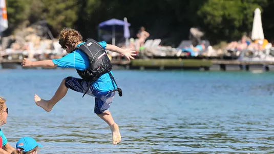 children jumping into the sea