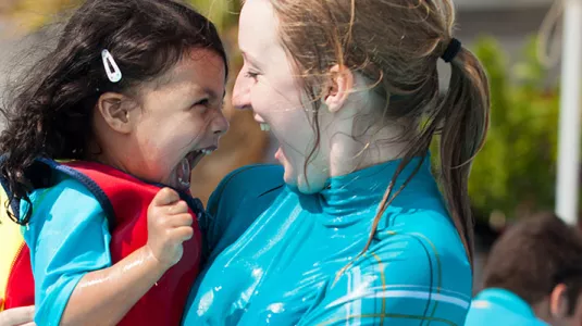 young girl and nanny playing in the pool
