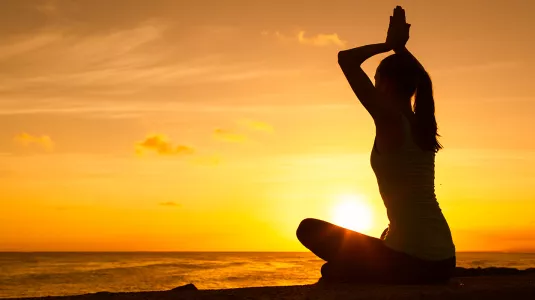 Girl meditating at sunset