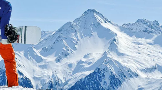 man standing holding a snowboard
