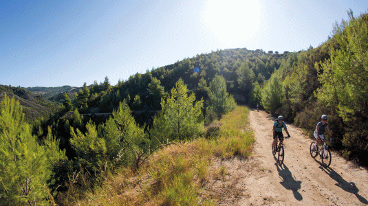 Two people cycling in Greek countryside