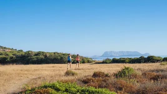 Two women running by the sea in Sardinia