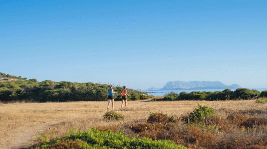 Two women running by the sea in Sardinia