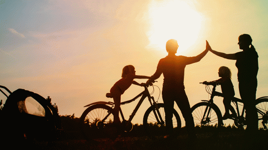 Family cycling at sunset