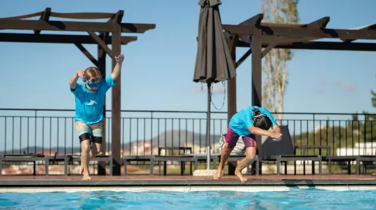 Kids jumping into a swimming pool