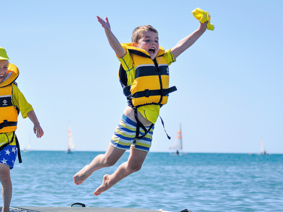 boys jumping from stand up paddle board